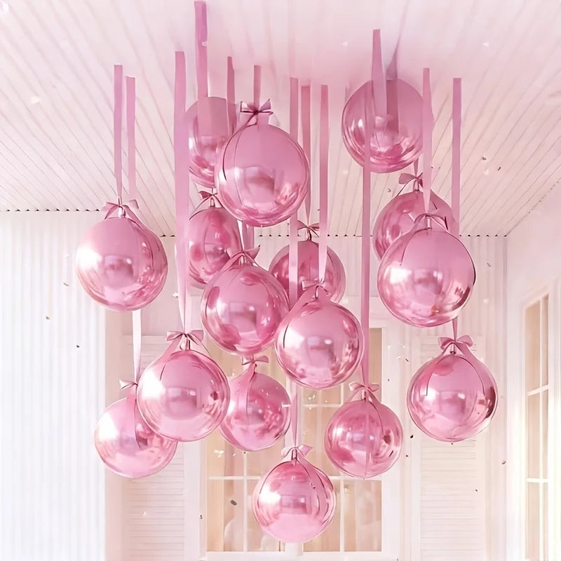 Una colección de globos metálicos rosados suspendidos del techo blanco.