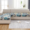 Sofá de exterior beige con tela estampada de hojas tropicales en cojines y asiento.