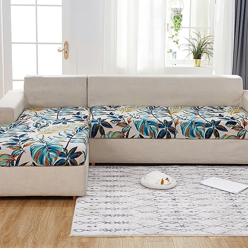 Sofá de exterior beige con tela estampada de hojas tropicales en cojines y asiento.