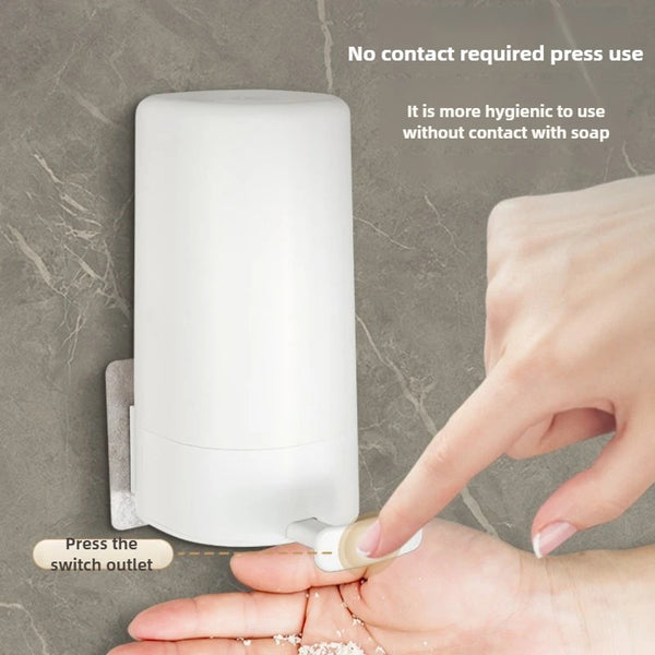 A hand is pressing the switch outlet on a white portable soap bar grinder, demonstrating no contact press usage.