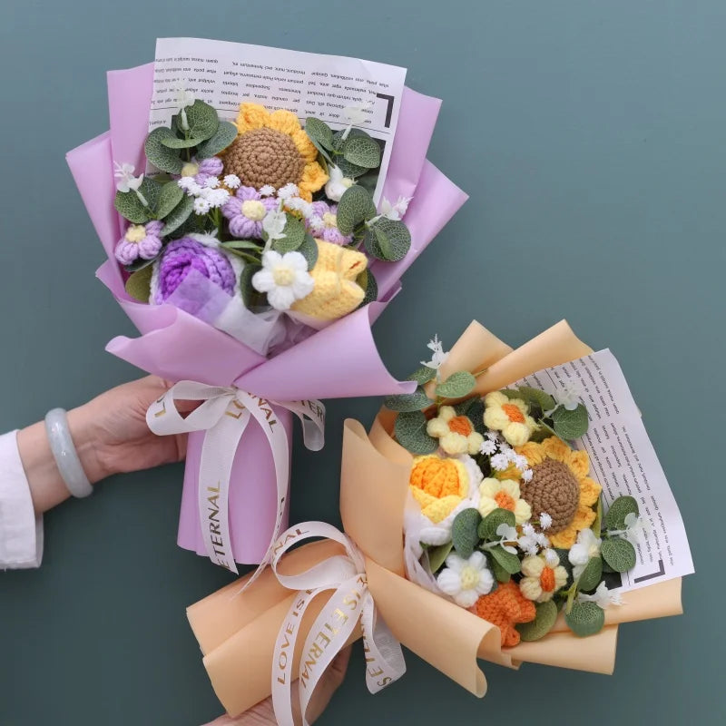 A handmade sunflower crochet bouquet wrapped in pink paper and tied with a white ribbon.