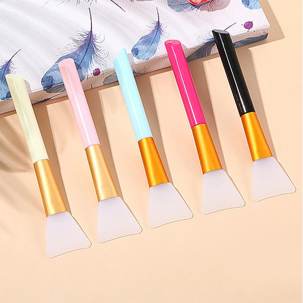 A set of six silicone facial mask brushes in various pastel colors, including pink, blue, and yellow.