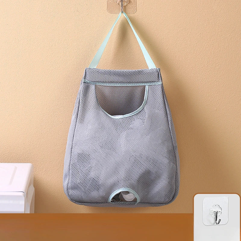 Gray mesh wall mounted garbage bag storage organizer hanging on a beige wall.