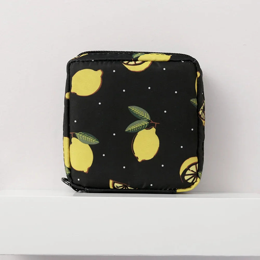 Black pouch with a yellow citrus fruit pattern, likely for sanitary pad storage.