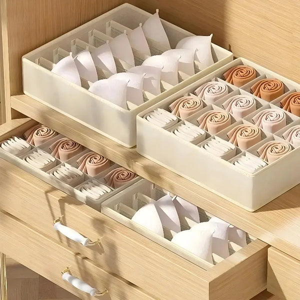 A set of fabric drawer organizer boxes with white and rose colored fabric rolls for closet and drawer storage.