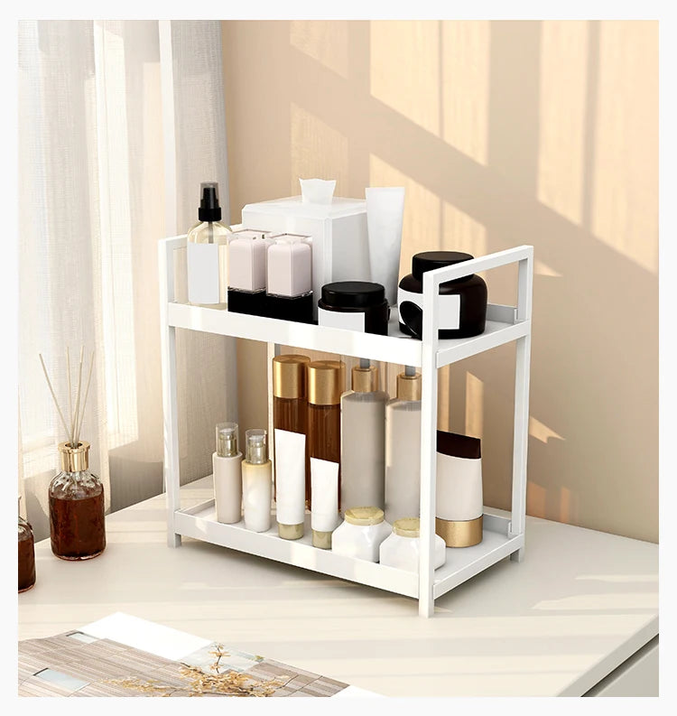 A white two-tier desktop storage rack holding various skincare and cosmetic bottles.