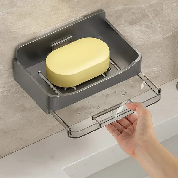 A hand is placing a yellow soap bar into a stainless steel wall mounted bathroom soap holder.