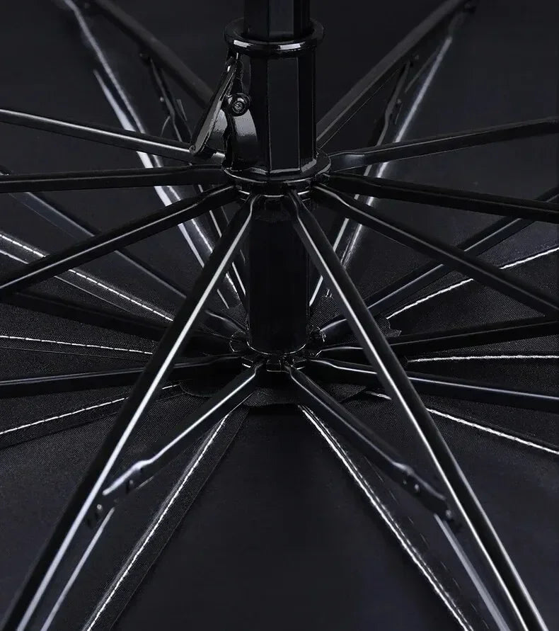 Close-up view of a black car sunshade umbrella with spokes and a central pole.