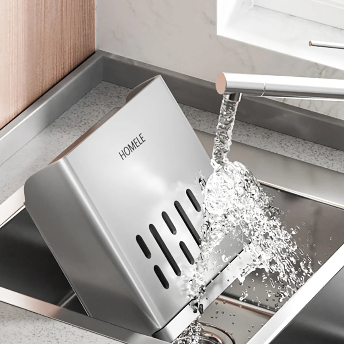 A stainless steel cutlery storage rack with a detachable drain base is shown pouring water into the sink.