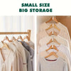 A collection of light-colored knit sweaters and shirts hanging on wooden clothes hangers for wardrobe organization.