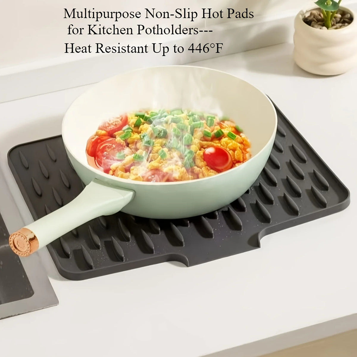 A light green silicone dish drying mat with raised drainage ridges is shown under a pot of food.