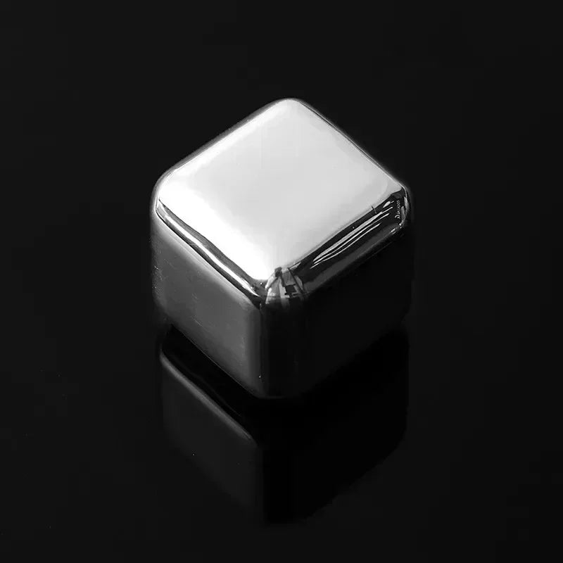 A square, reflective stainless steel whiskey ice cube resting on a dark surface.