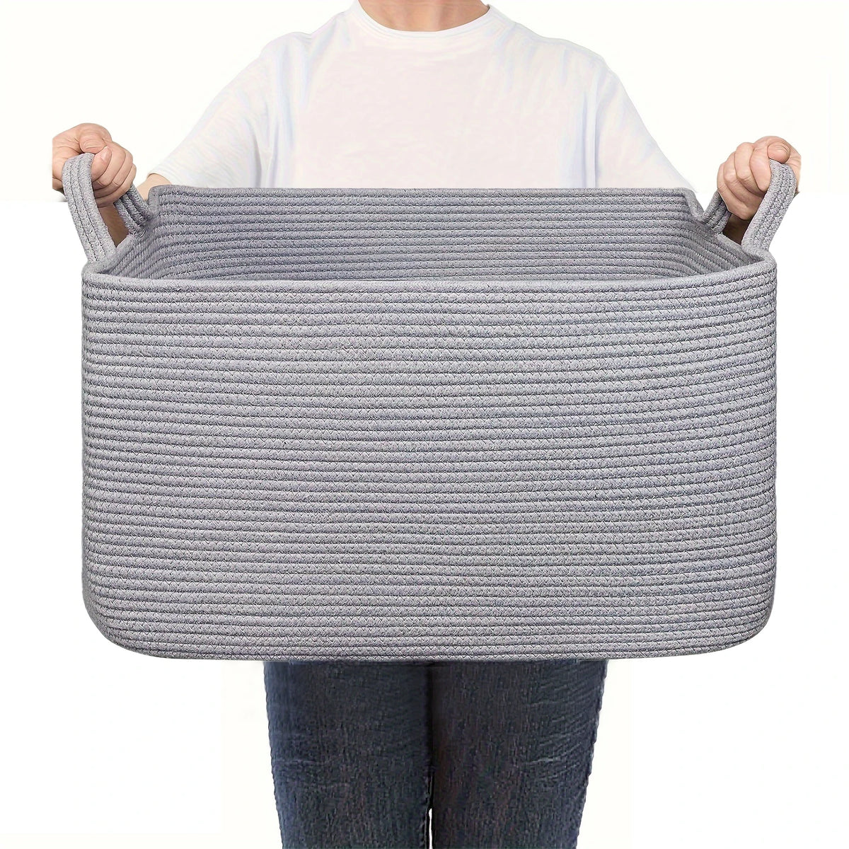 A gray woven cotton storage basket being held by a person.