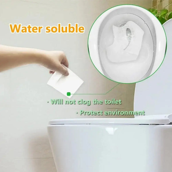 A hand places a water soluble toilet seat cover into a toilet bowl, demonstrating its ability to prevent clogging and protect