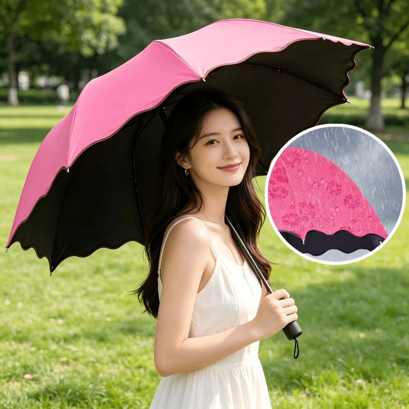 A woman holds a pink and black reversible umbrella in a sunny park setting.