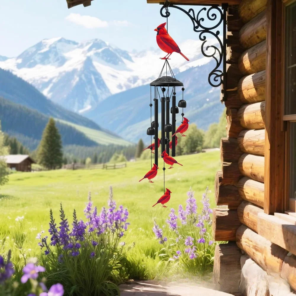 A red bird hangs from an ornate metal wind chime decoration near a wooden building with a scenic mountain view.