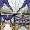 Blue sheer chiffon draping fabric suspended from a ceiling structure for an event