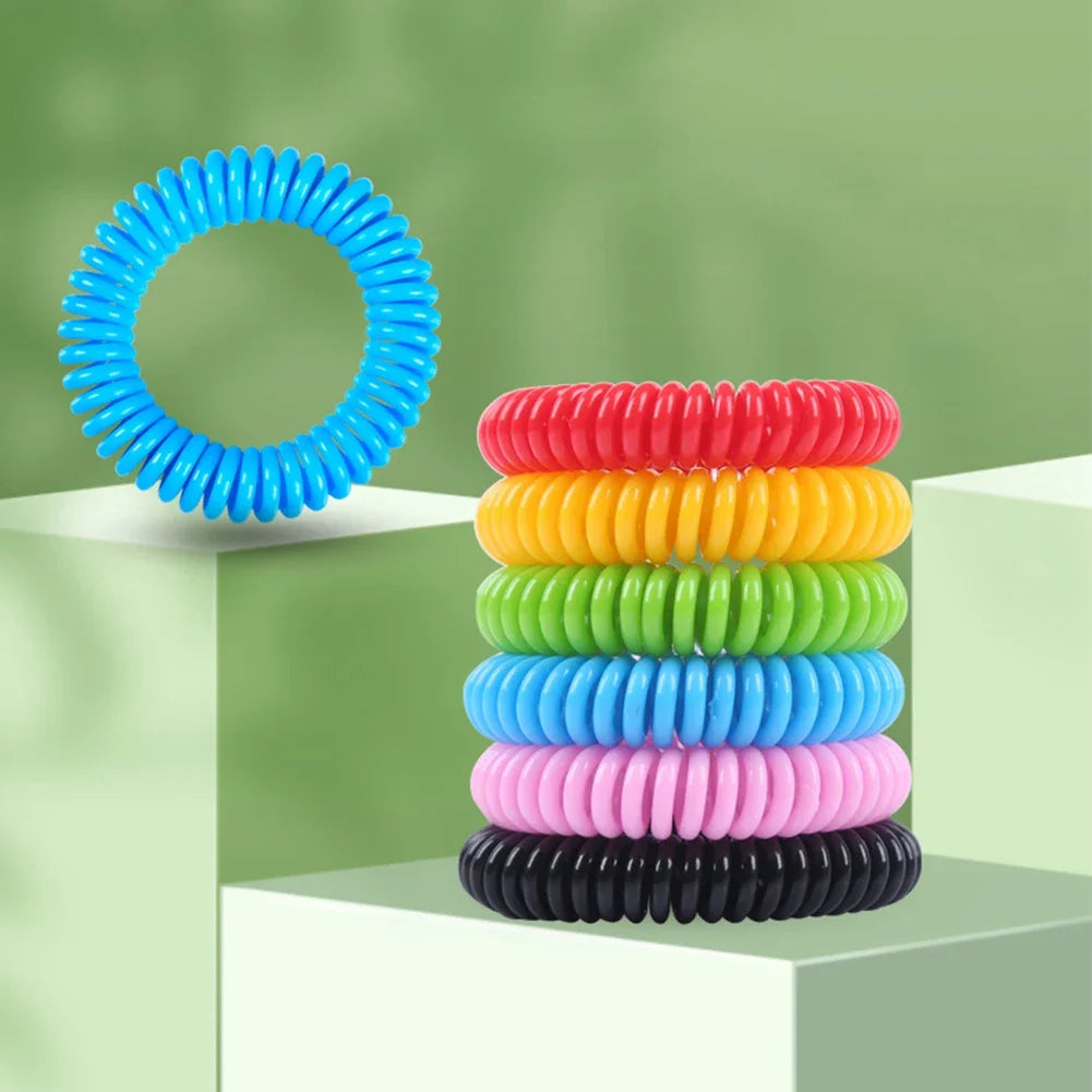 A stack of ten colorful silicone bracelets in various colors, including blue, red, yellow, green, and pink, displayed on a wh