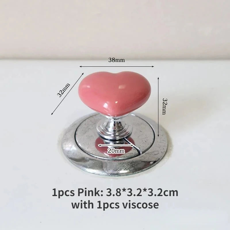Bouton de chasse d'eau en forme de cœur rose avec une base argentée