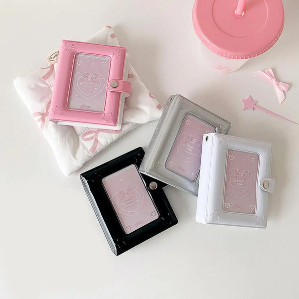 Eine Sammlung quadratischer Fotoalben in rosa und silbernen Tönen, darunter ein rosa Plastikalbum, ein silbernes durchsichtig