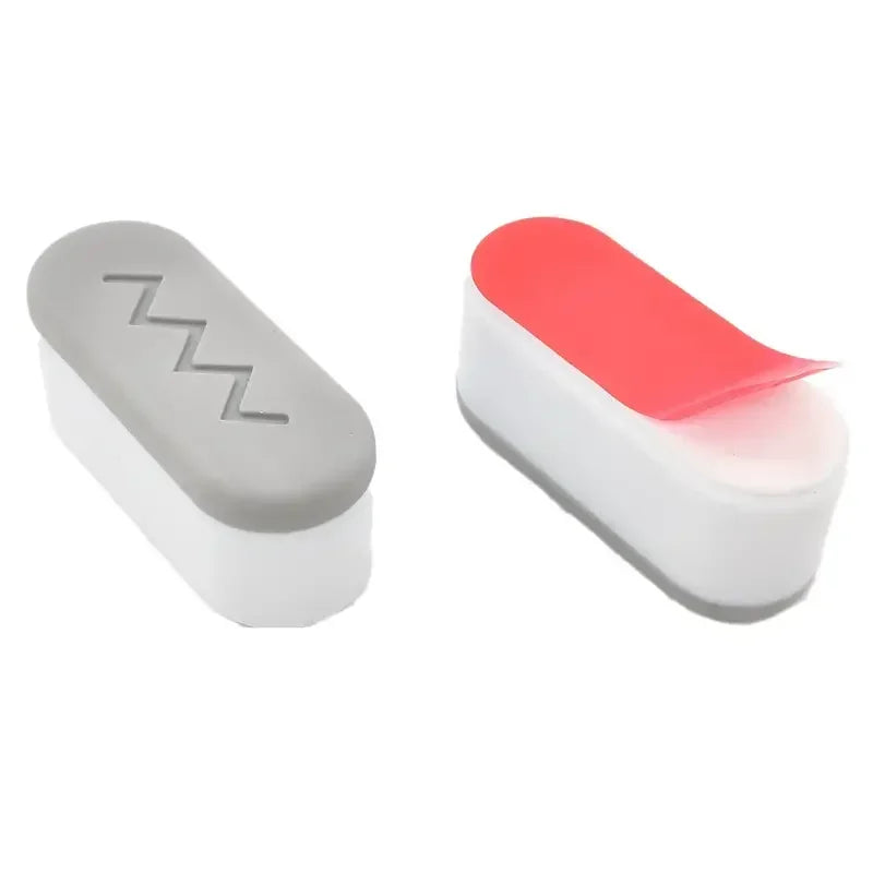 A pair of white toilet seat vibration dampening and protection pads with red accents.