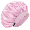 A pink silk sleep cap with gathered fabric and a black strap.