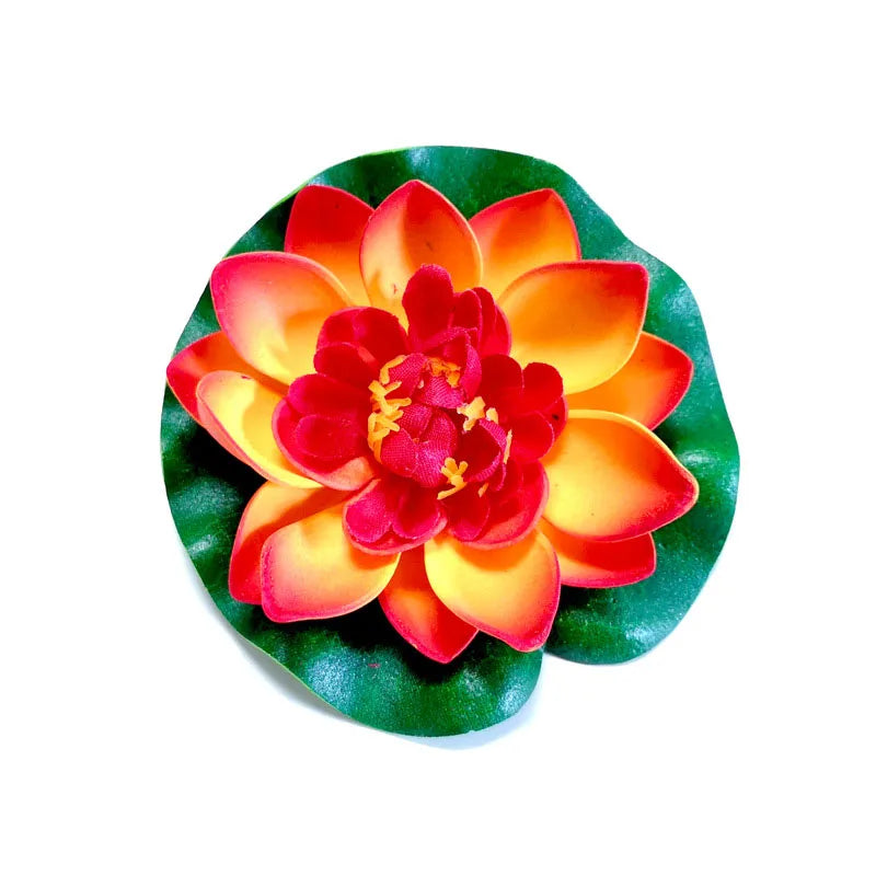 A vibrant artificial lotus flower with orange and red petals set against a green leaf.