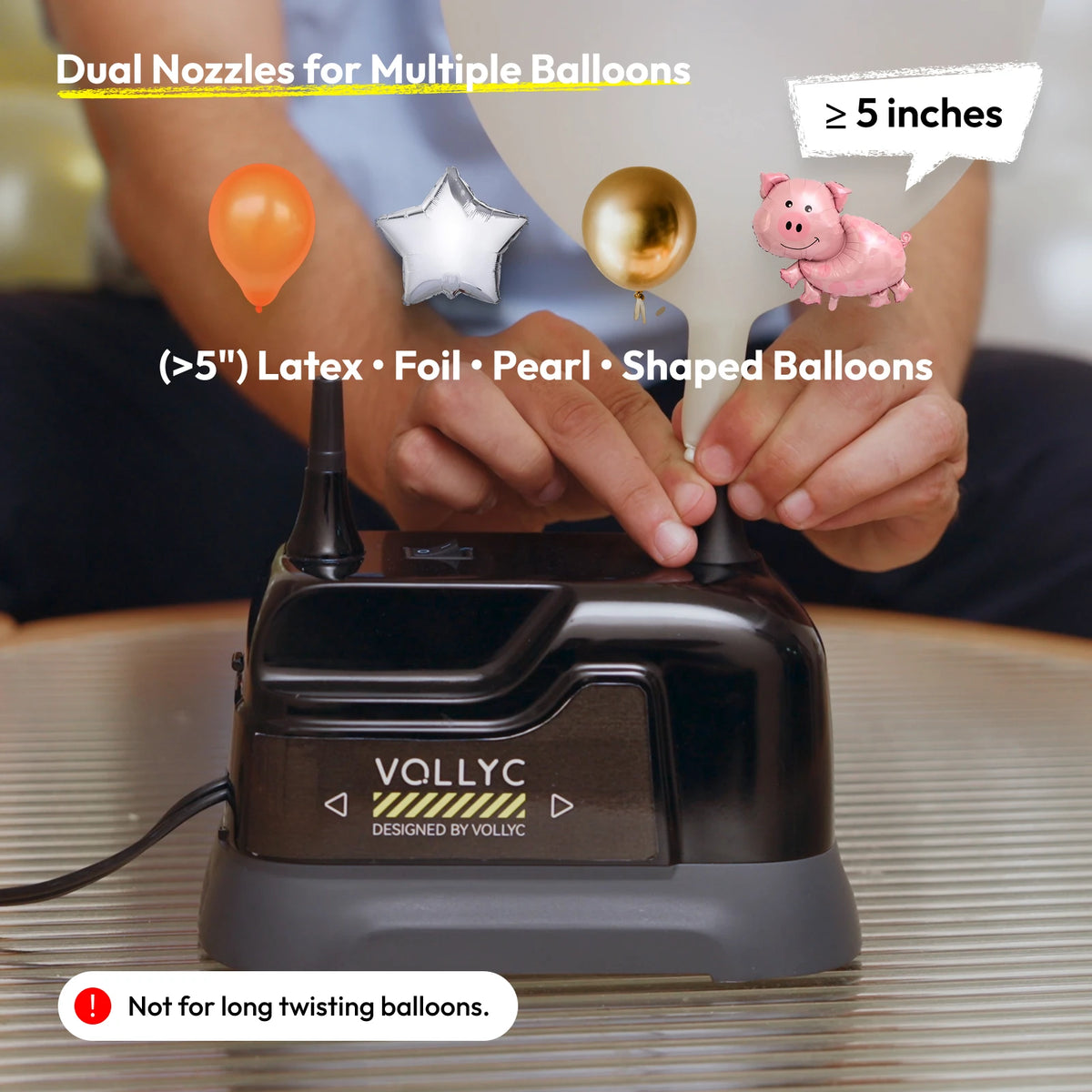 A hand is using a Vollyc electric balloon inflator pump to inflate various shaped balloons.