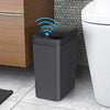 Moderner grauer smarter Bewegungssensor-Mülleimer neben einer Toilette und einem Holzschrank