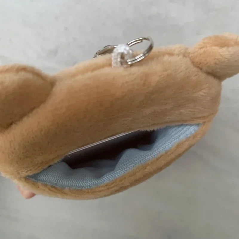 A fluffy brown Rilakkuma plush toy is shown with its mouth open, revealing a light blue interior and a silver keychain ring.