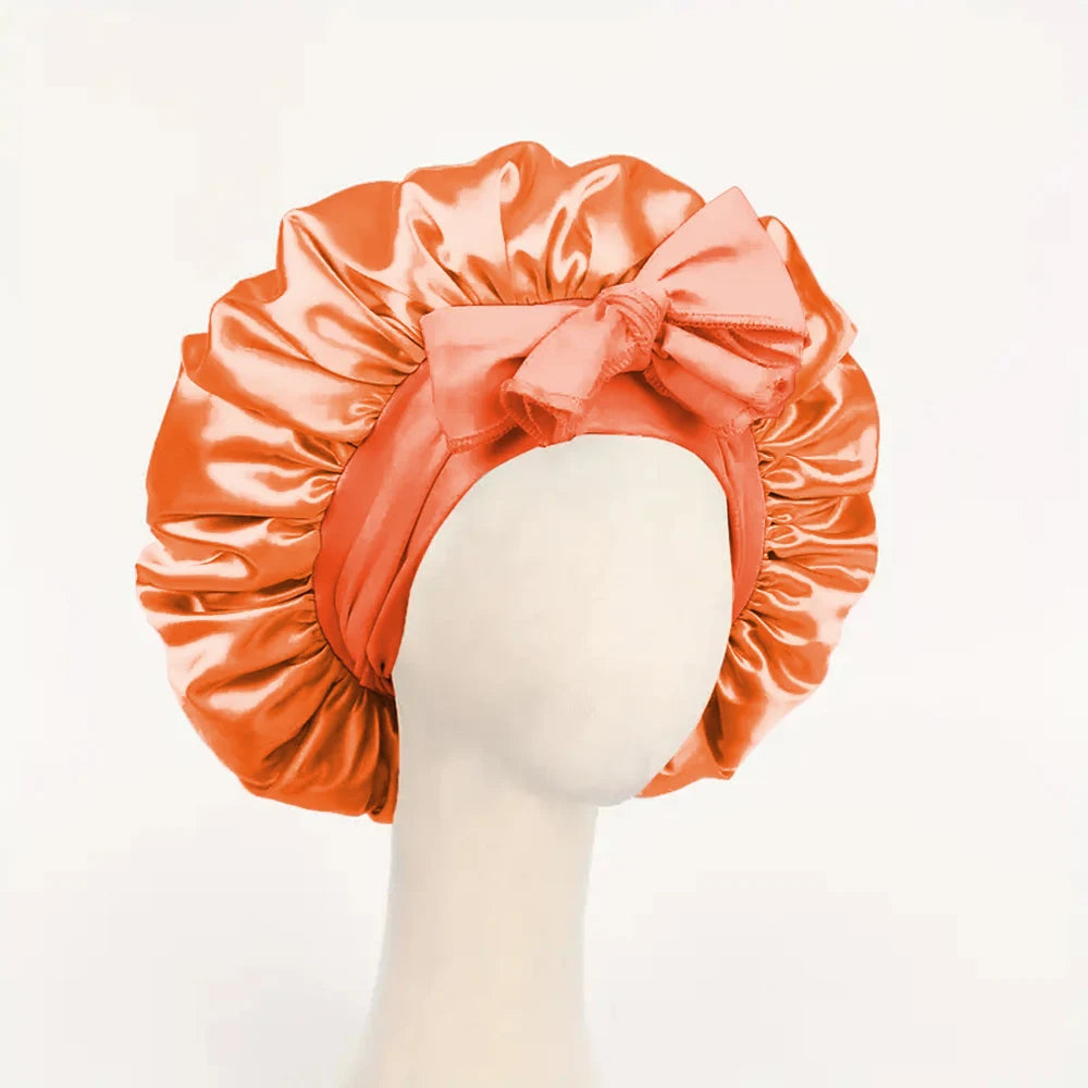 Orange Seiden-Haube mit Schleife auf einem Mannequin-Kopf.
