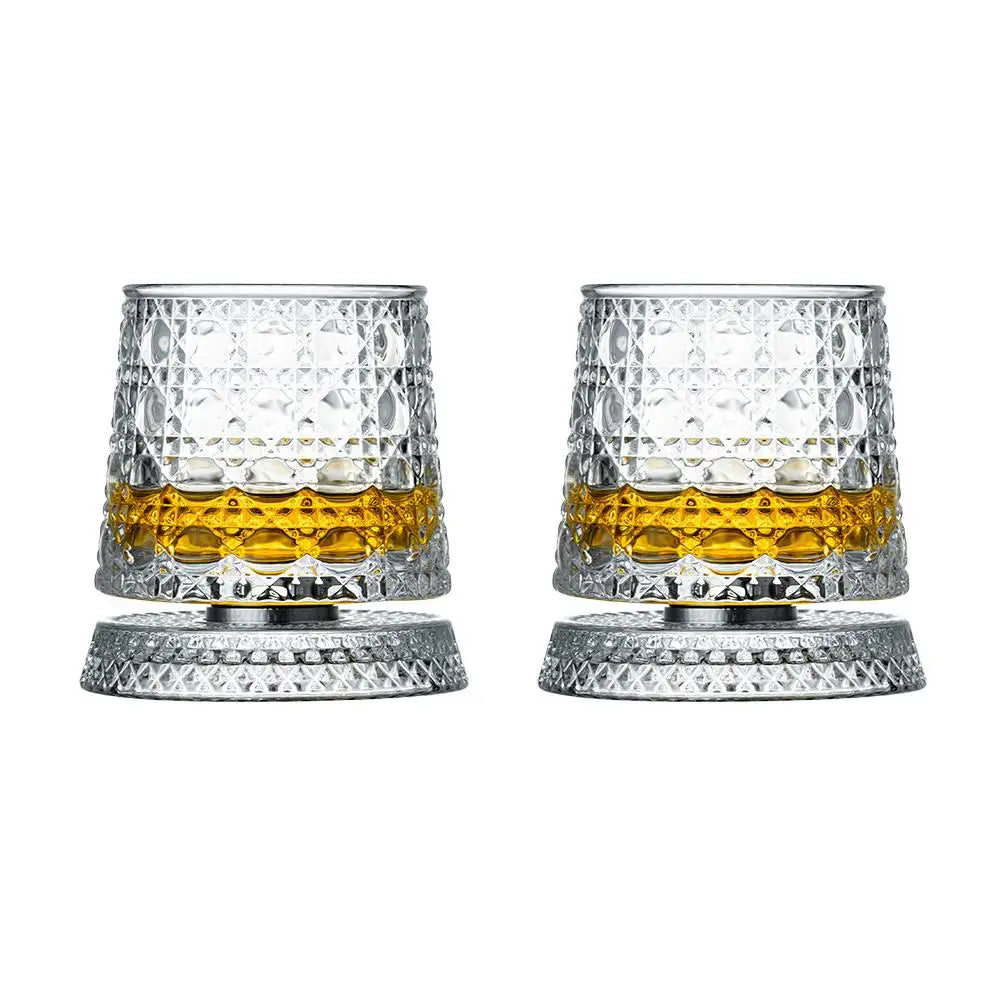 Un par de vasos de whisky texturizados y facetados con detalles dorados y bases a juego.