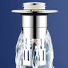 A close-up view of a stainless steel brass sink drain strainer with a removable filter, surrounded by water.
