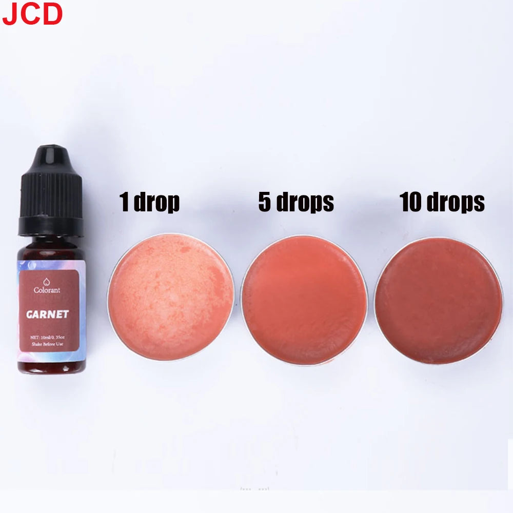 A bottle of Garnet liquid candle dye next to three circular samples showing 1, 5, and 10 drops of the reddish-pink color.