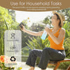 A woman sprays a plant with a high pressure mist spray bottle outdoors.