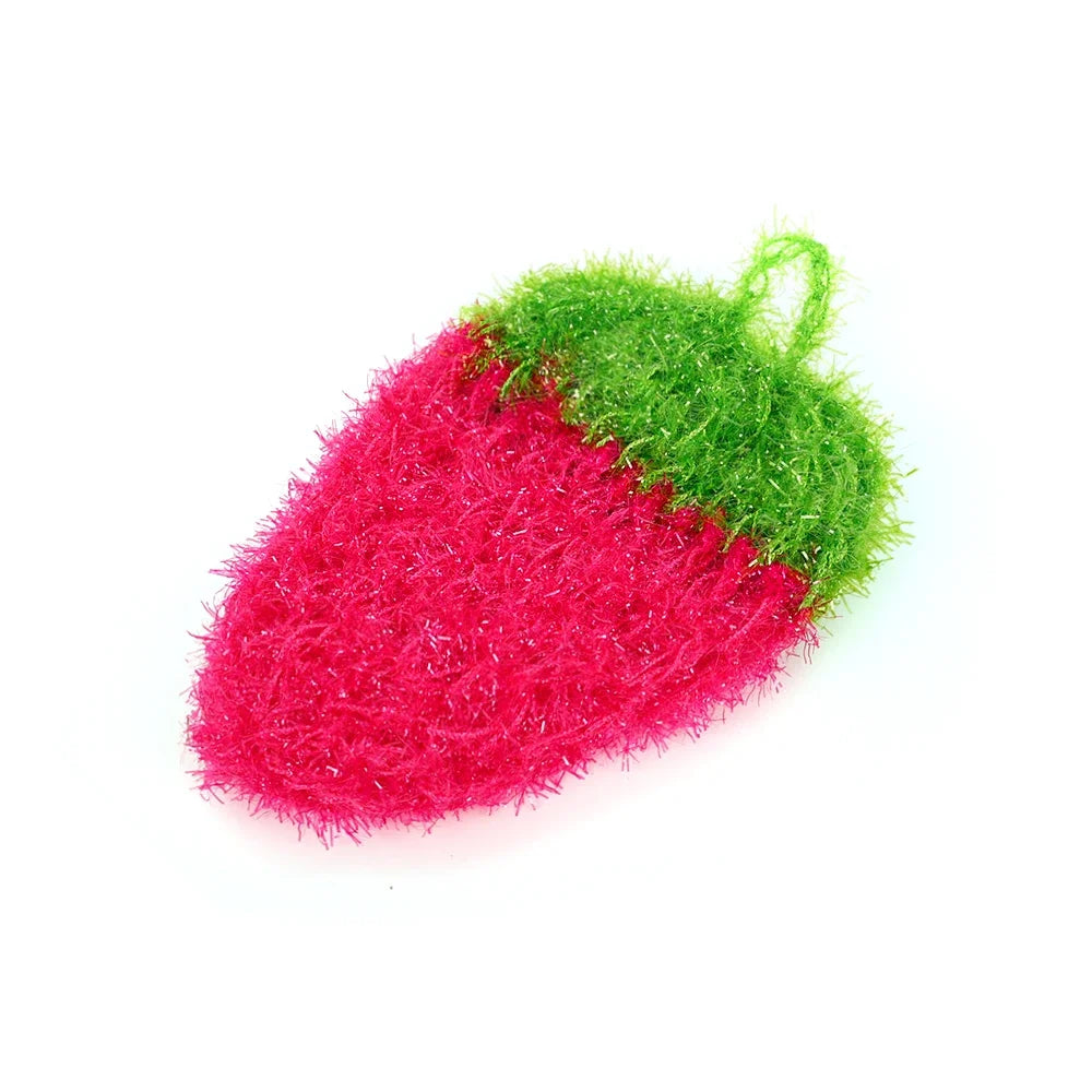 A bright pink strawberry scrubber sponge with a green top, used for kitchen cleaning.