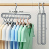 A set of three light-colored plastic hangers hanging from a wooden rod.