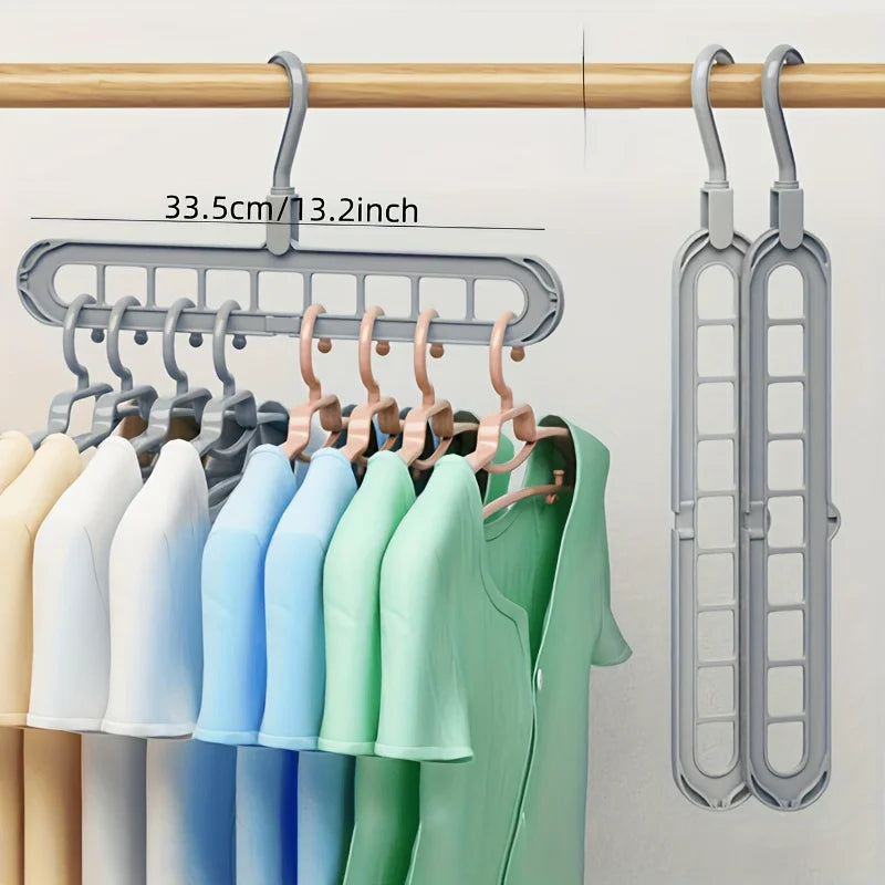 A set of three light-colored plastic hangers hanging from a wooden rod.