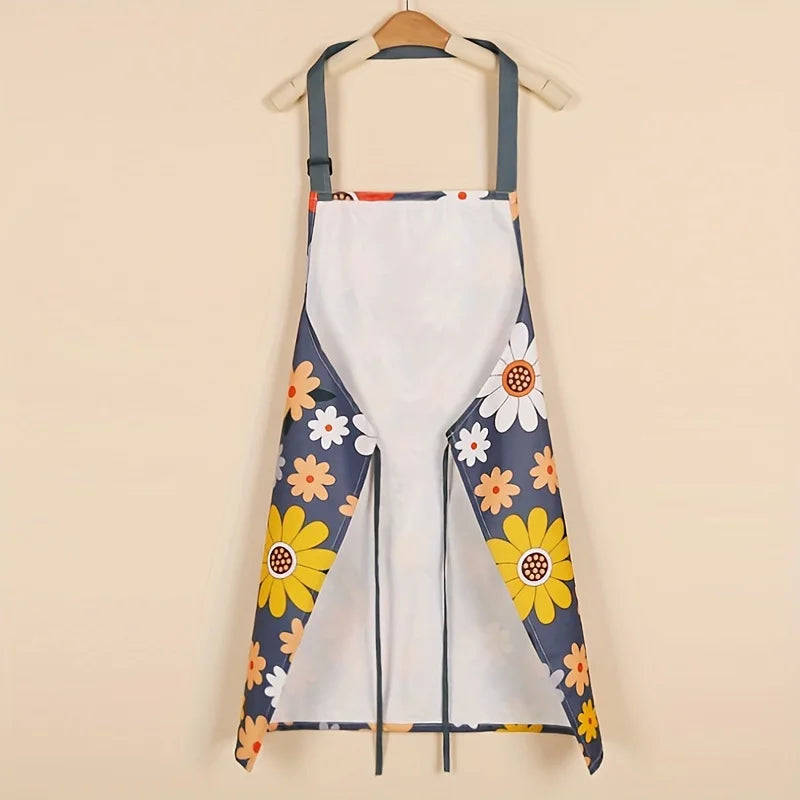 A white kitchen apron with a floral print featuring yellow and blue daisies, hanging on a wooden hanger.