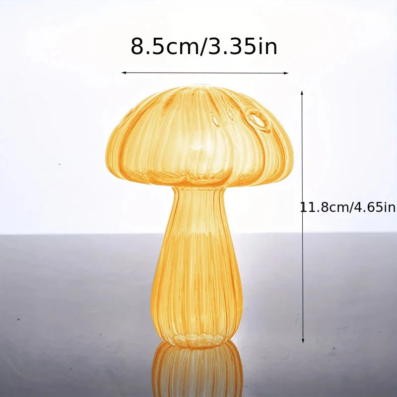 A clear glass mushroom vase with a smooth cap and stem, shown against a light background.