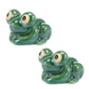 A pair of glossy green ceramic toilet bolt covers shaped like small frogs.
