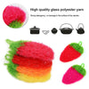 A variety of colored glass polyester yarn fibers shown next to a strawberry-shaped scrubber sponge.