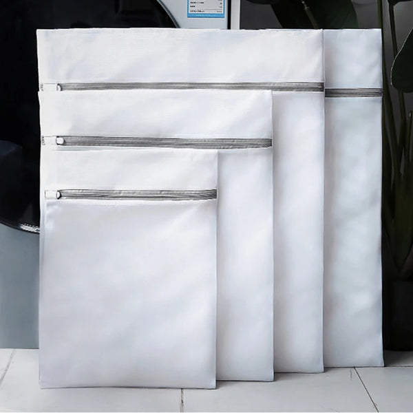 A stack of white mesh laundry bags folded and displayed on a surface.