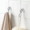 A beige towel hangs from a self-adhesive stainless steel wall hook on a white tiled surface.