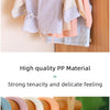 A collection of light-colored plastic clothes hangers for baby and child clothing.