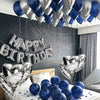 A silver and blue foil balloon garland decorating a room, with balloons on a white table.