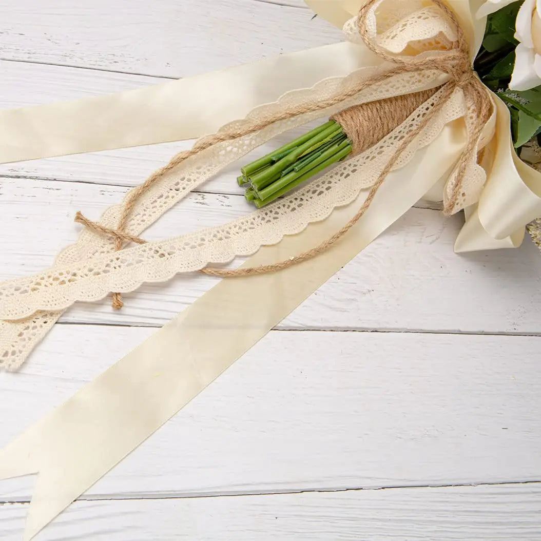 A beige ribbon tied with twine and lace decorates an elegant artificial rose wedding bouquet.