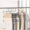 Multi-layer stainless steel pants rack displaying various folded clothing items hanging on a rod.