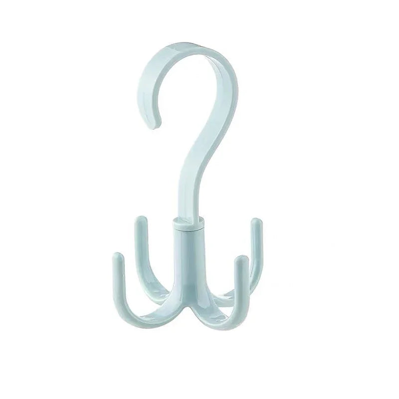 A clear plastic space-saving rotating closet organizer hook with a curved handle and three hanging arms.