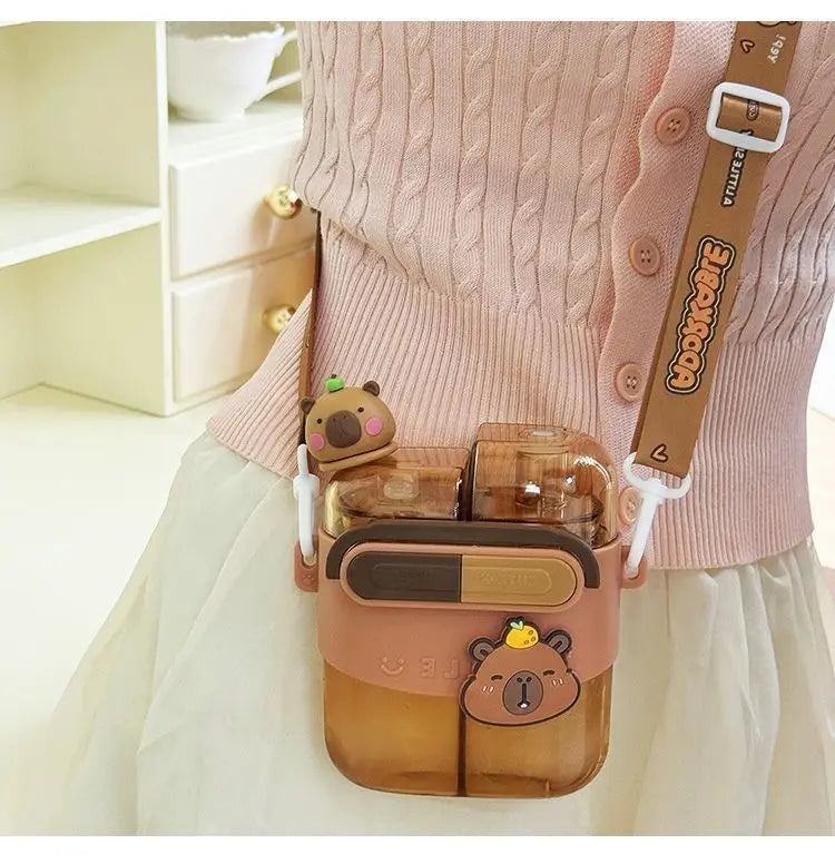 كم sweater وردي يظهر كم قبعة كابيبارا زجاجة ماء مزدوجة مع مصاصة متصلة بالذراع.